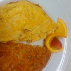 A picture of Good breakfast ham and tomato omelette with hash brown.