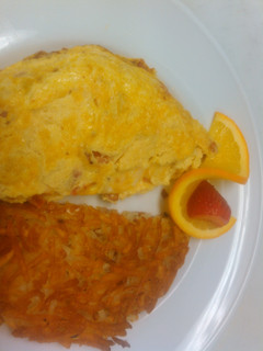A picture of Good breakfast ham and tomato omelette with hash brown.
