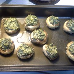 A picture of Mushrooms stuffed with spinich and onions.