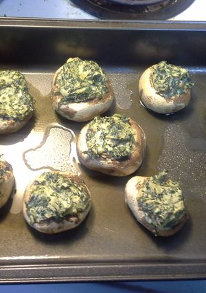 A picture of Mushrooms stuffed with spinich and onions.