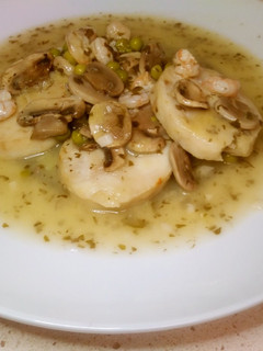 Una foto de Merluza en salsa verde con guarnición de gambas y champiñones