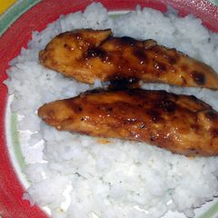 A picture of sweet n sour chicken over rice.