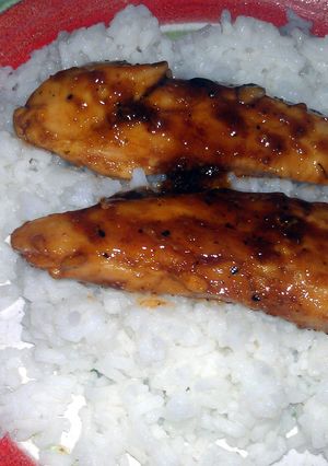 A picture of sweet n sour chicken over rice.