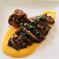 A picture of Chuck steak over a butternut puree and sauted mushrooms.