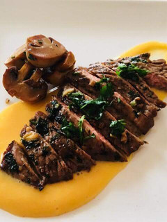 A picture of Chuck steak over a butternut puree and sauted mushrooms.