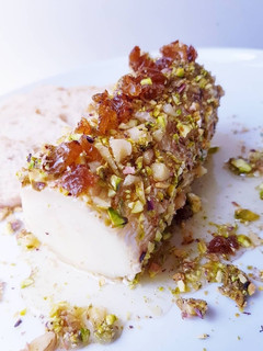 Una foto de Queso de cabra con pistacho, nueces y miel tibia