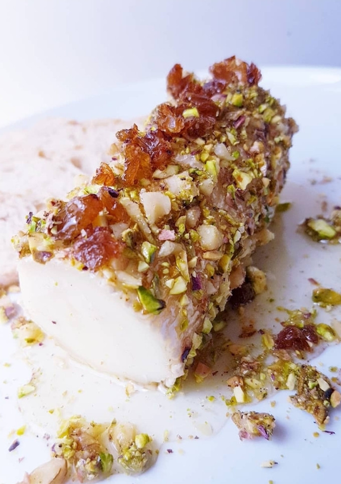 Una foto de Queso de cabra con pistacho, nueces y miel tibia