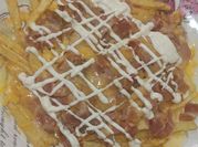 Una foto de bacon cheese fries