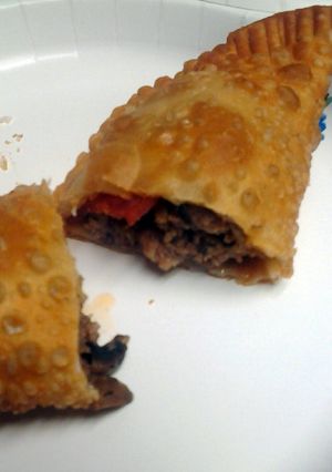 A picture of four meat empanadas.