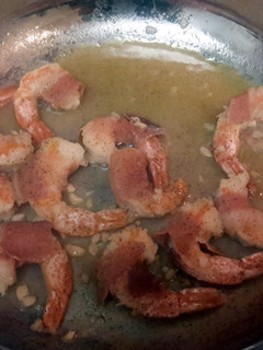 A picture of prosciutto - wrapped Shrimp with Arugula Salad.