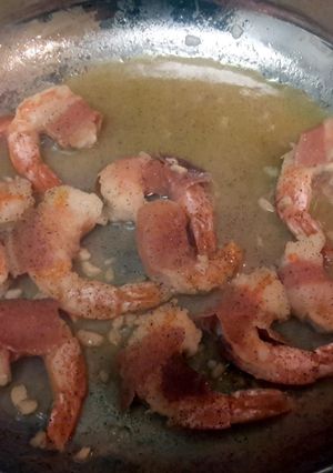A picture of prosciutto - wrapped Shrimp with Arugula Salad.