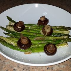 A picture of Asparagus with brown mushrooms.