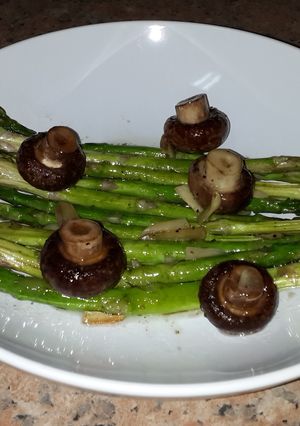 A picture of Asparagus with brown mushrooms.