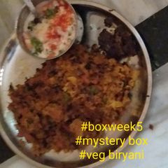 A picture of Veg biryani and onion tomato raita.