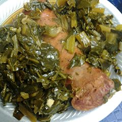 A picture of Smoked sausage with collard greens.