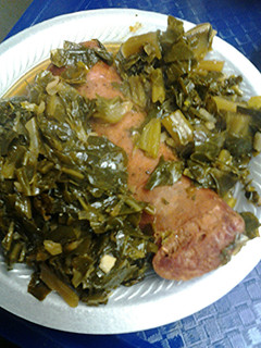A picture of Smoked sausage with collard greens.