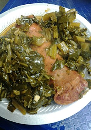 A picture of Smoked sausage with collard greens.