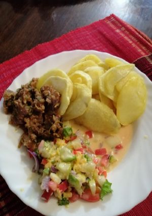 A picture of Roasted potatoes, kachumbari in castor milk and fried beef.