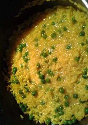 A picture of tumeric rice with peas.