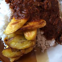 A picture of Rice and stew with plantain.
