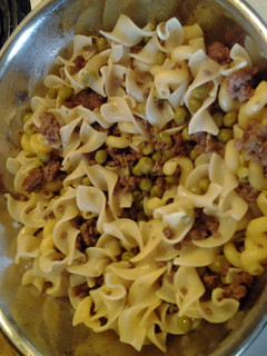 A picture of Ground Beef w/ egg noodles an sweetpeas.