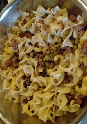 A picture of Ground Beef w/ egg noodles an sweetpeas.