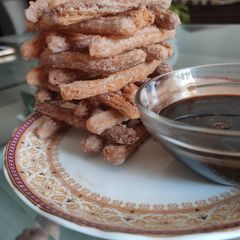 A picture of Churros with chocolate sauce.