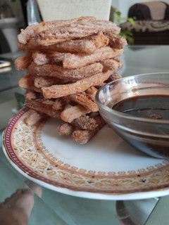 A picture of Churros with chocolate sauce.