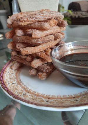 A picture of Churros with chocolate sauce.