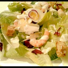 A picture of Ceaser salad with prawns.