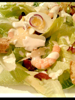 A picture of Ceaser salad with prawns.