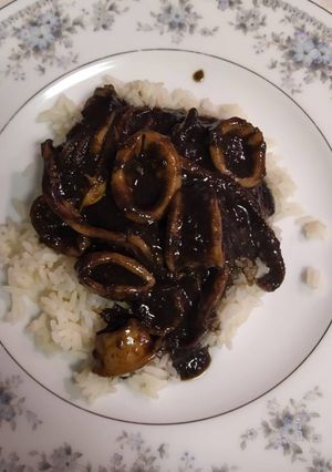 Una foto de Calamares encebollados en tinta con arroz blanco