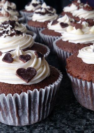 A picture of chocolate cupcakes with buttercream and chocolate toppings..