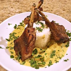 A picture of Potato in yellow curry sauce with grilled lamp chops.