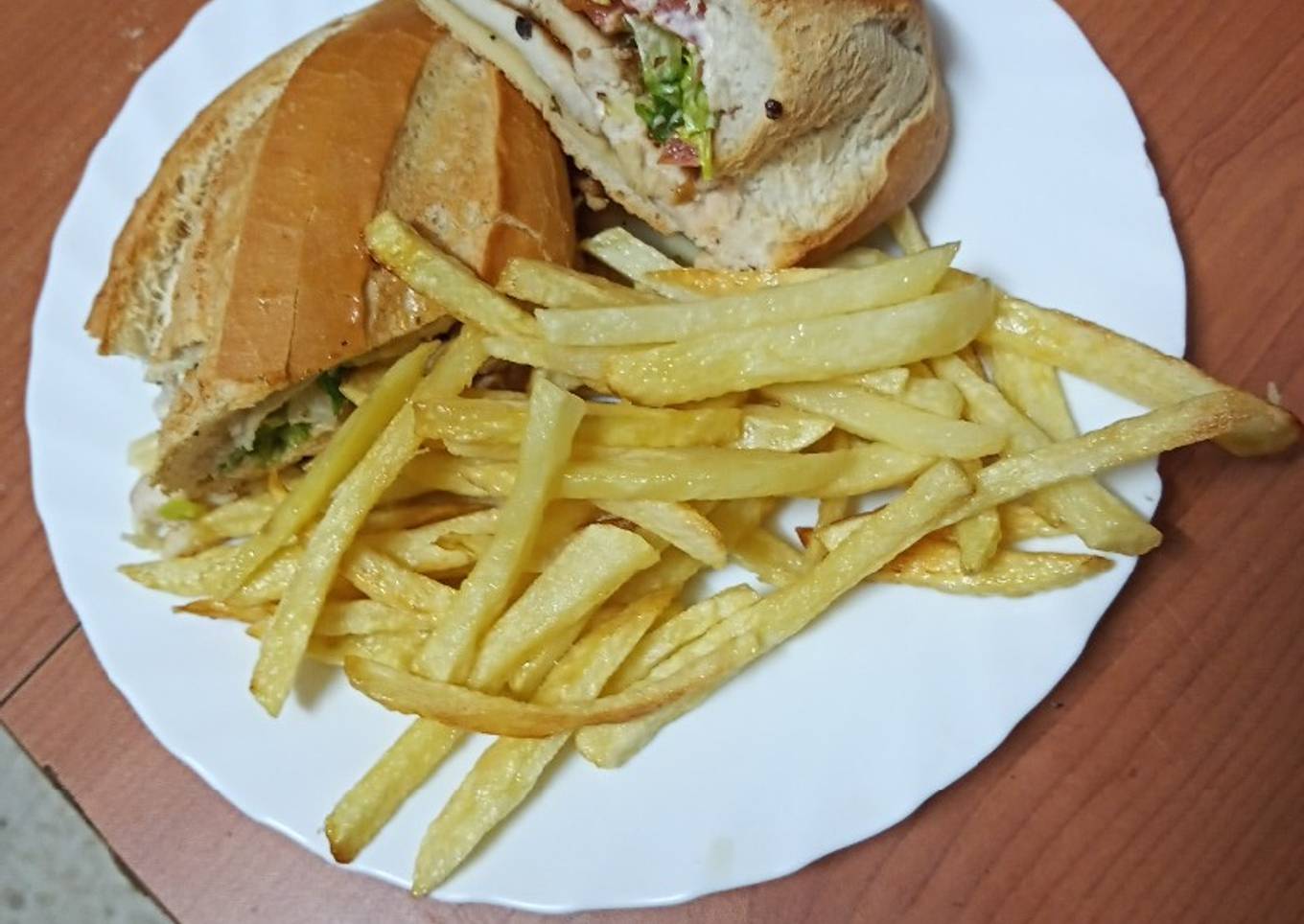 Bocadillo de pechuga, lechuga y queso con papas fritas