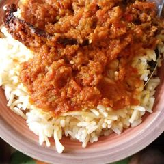A picture of White rice mix with spaghetti and fish stew.