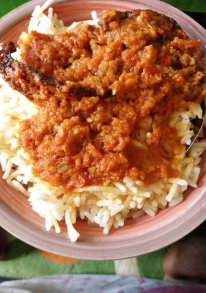 A picture of White rice mix with spaghetti and fish stew.
