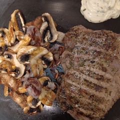 A picture of Grilled Ribeye Steak with Grilled Shallots and Chestnut Mushrooms.