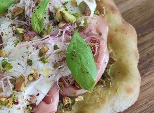 Une photo de Pinsa pesto mortadelle pistache