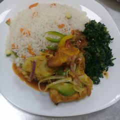 A picture of Oven baked chicken, steamed vegetable rice n fried sukuma wiki.