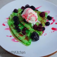 A picture of Indonesian crepes with ice cream and mixberry on top.
