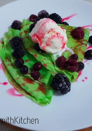 A picture of Indonesian crepes with ice cream and mixberry on top.