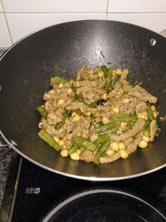 Una foto de Wok de cordero al curry salteado con espárragos verdes y garbanzos