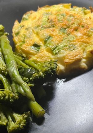 A picture of Spring onion & Cheese baked omelette with buttered vegetables.