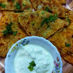 A picture of Aloo paratha with curd.
