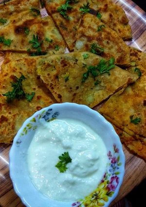 A picture of Aloo paratha with curd.