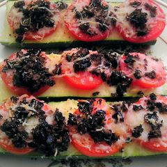 A picture of Baked zucchini topped with tomatoes & cheese.