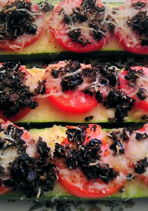 A picture of Baked zucchini topped with tomatoes & cheese.
