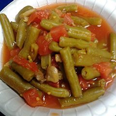 A picture of Green beens with mushrooms and tomatoes.