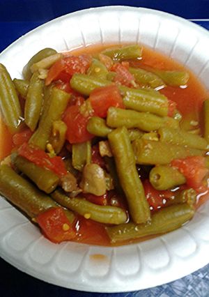 A picture of Green beens with mushrooms and tomatoes.